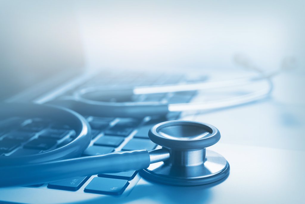 stethoscope on top of a laptop